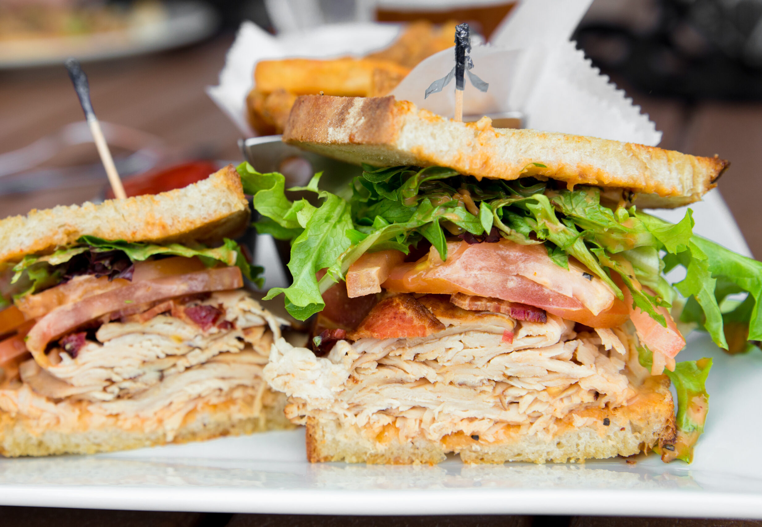Turkey club with lettuce and tomatoes.