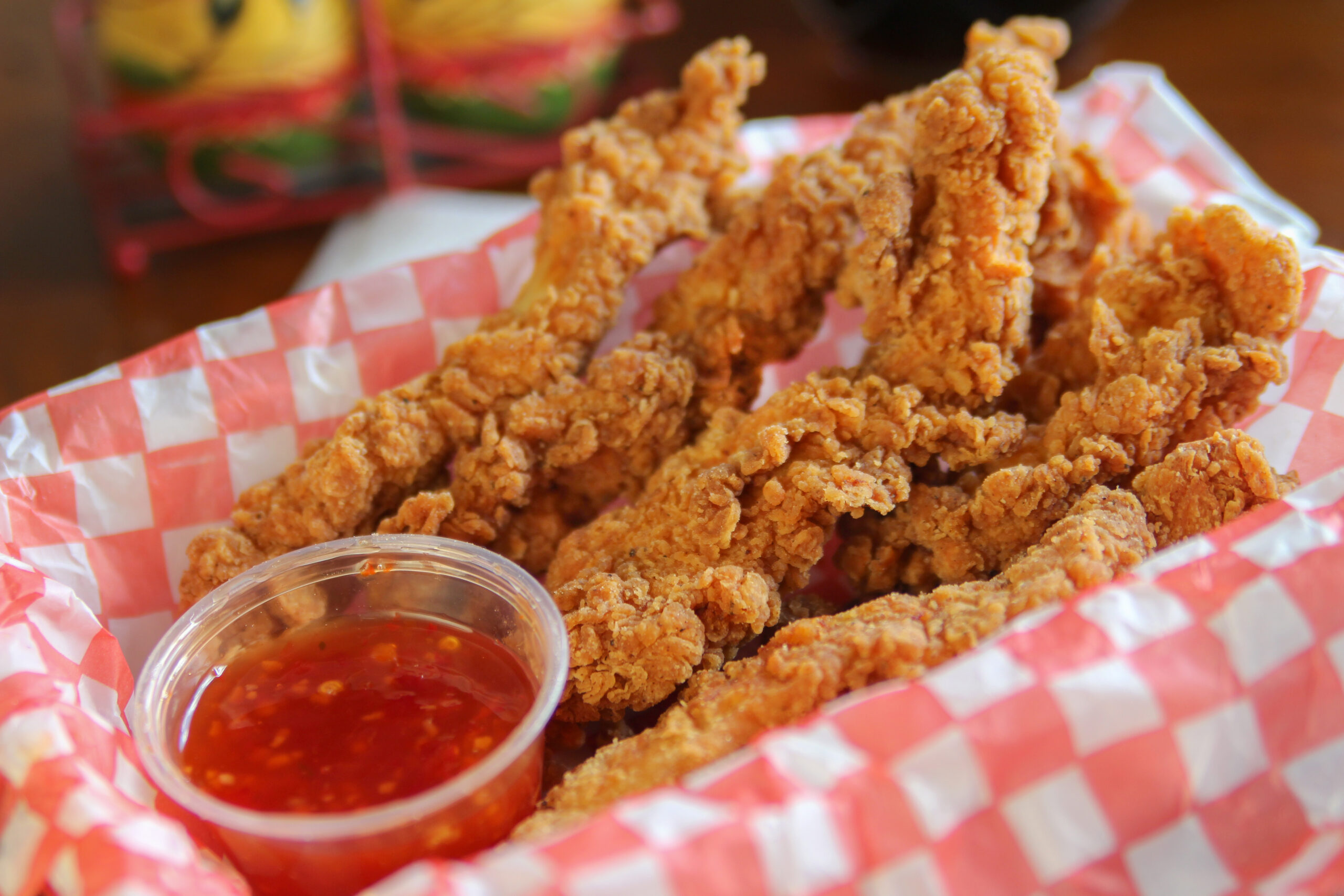 Chicken tenders with ketchup on a basket.