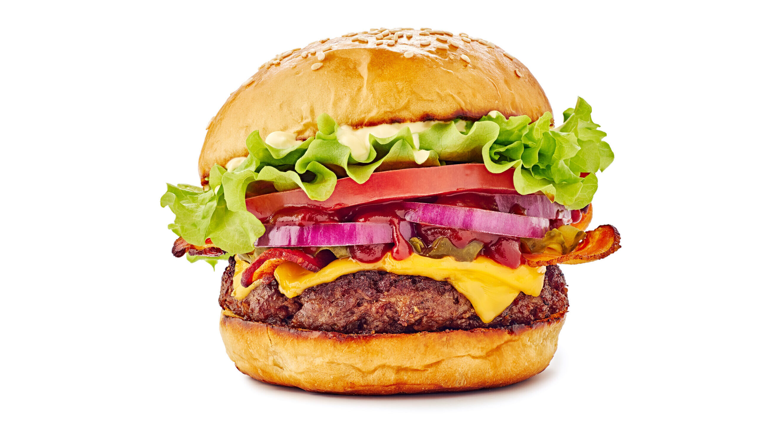 Hamburger with cheese, lettuce, tomatoes, and ketchup.