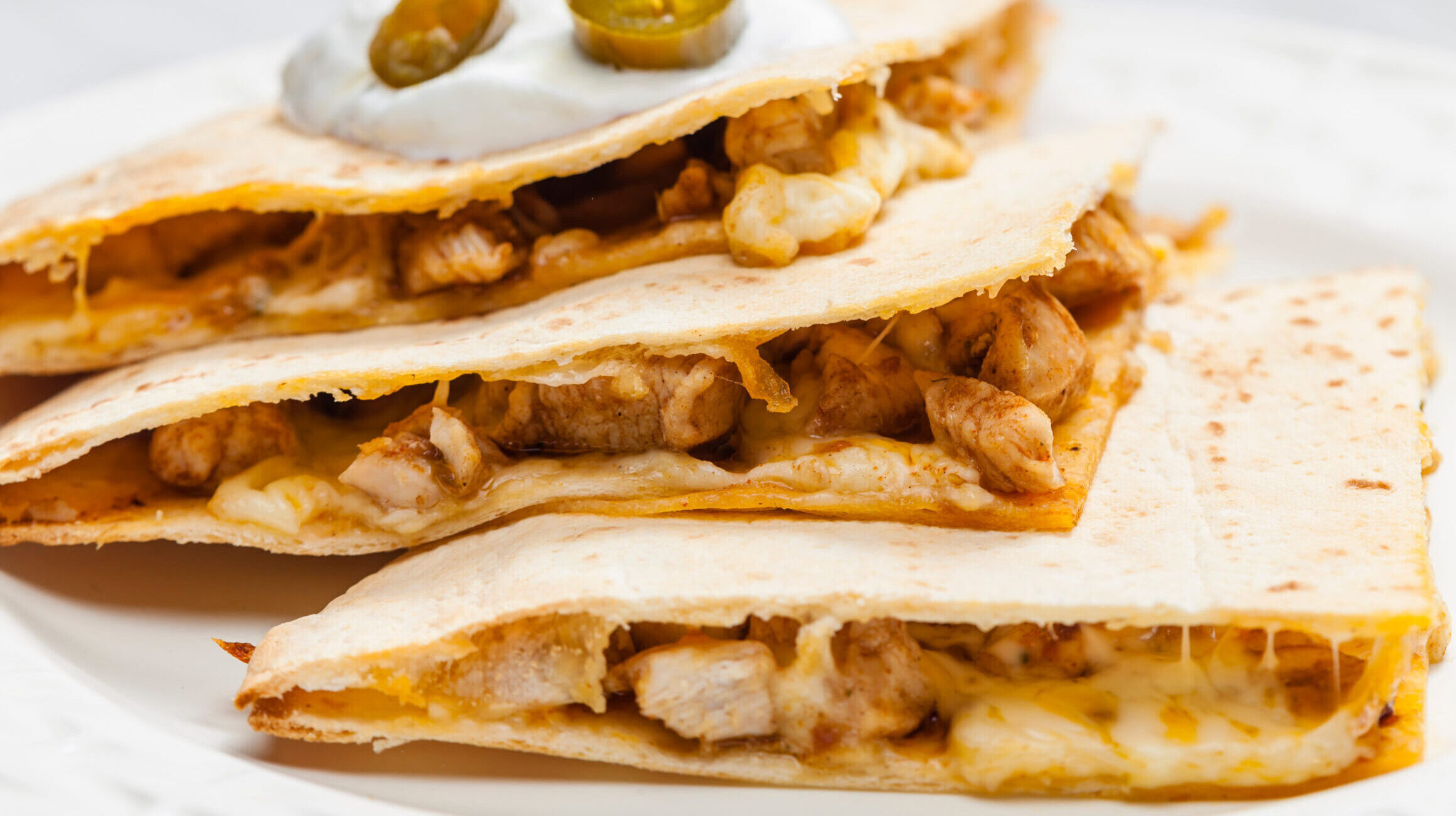 Chicken quesadilla with cheese and sour cream.